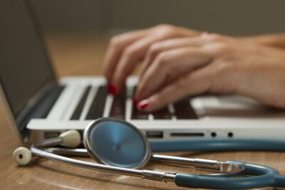 Pedir cita en el centro de salud por internet: estetoscopio junto a un ordenador portátil